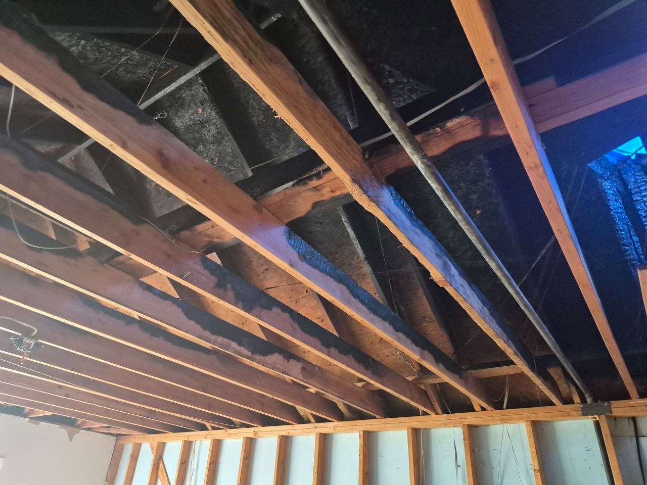 Exposed timber ceiling framing with visible fire damage